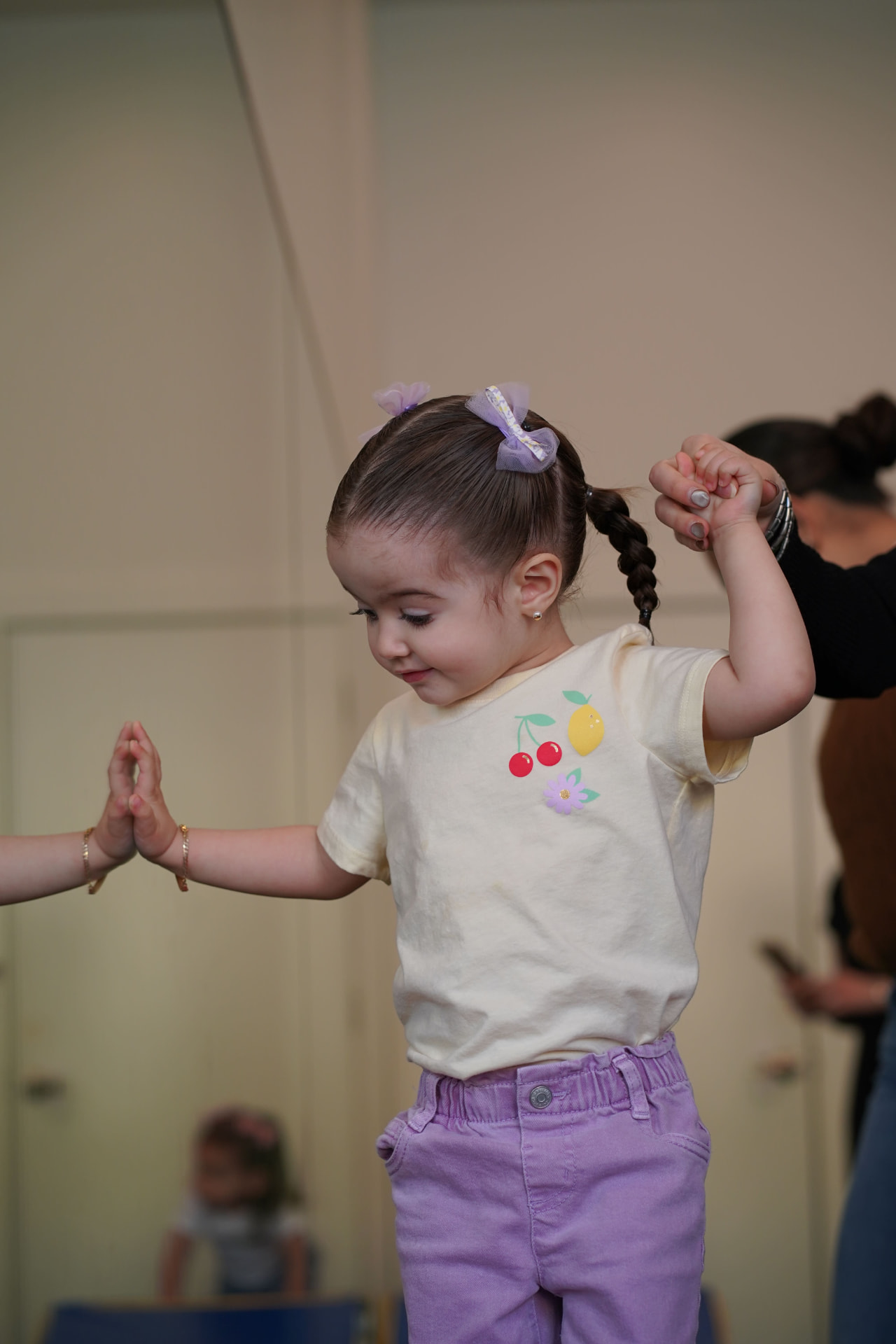 Niña caminando en una viga de equilibrio con apoyo de una maestra
